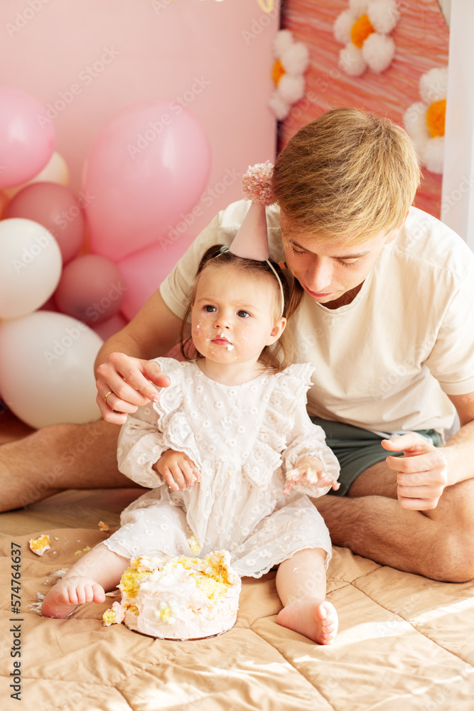 One year old little girl with daddy solemnize birthday and eat cake. Family and love One year old little girl with daddy solemnize birthday and eat cake. Family and love