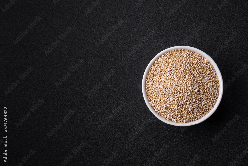 Wholesome raw quinoa in a bowl on a dark concrete background Wholesome raw quinoa in a bowl on a dark concrete background