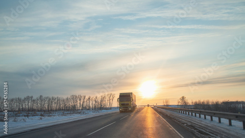 Truck on a suburban highway at sunset in spring. Logistics, cargo transportation.