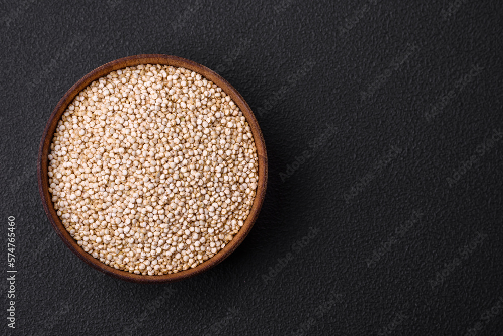 Wholesome raw quinoa in a bowl on a dark concrete background Wholesome raw quinoa in a bowl on a dark concrete background