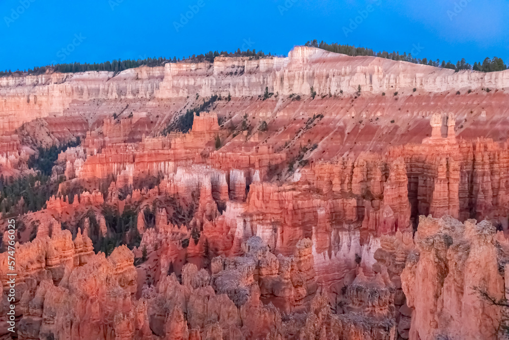 Panoramic morning sunrise view on sandstone rock formations on Navajo Rim hiking trail in Bryce Canyon National Park, Utah, UT, USA. Golden hour colored hoodoo rocks in unique natural amphitheatre