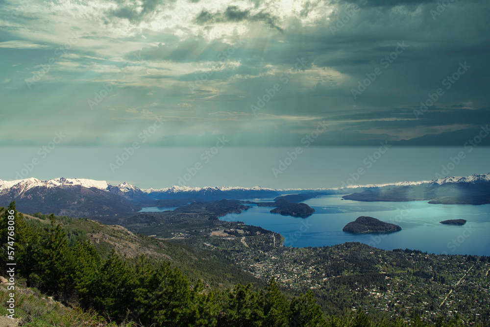 Panoramic view of the lakes of Bariloche from Cerro Otto. Sky with storm and rays of sunshine