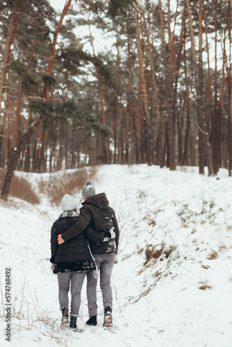 Young couple walking in cold field together holding hands and freezing