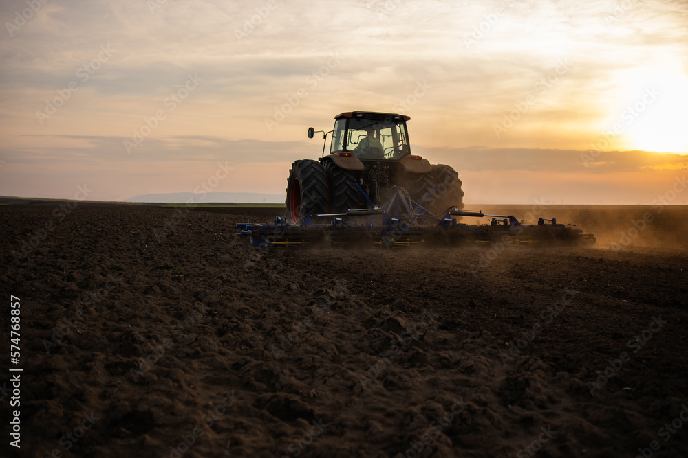 Fototapeta premium Farmer preparing his field in a tractor