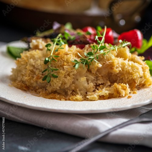 Salt cod brandade garnished with thyme. Salt cod is blended with potatoes, milk, garlic, and olive oil, then baked in a casserole or au gratin pan.
