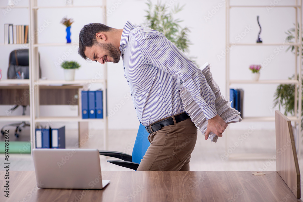 Young male employee and too much work in the office Young male employee and too much work in the office