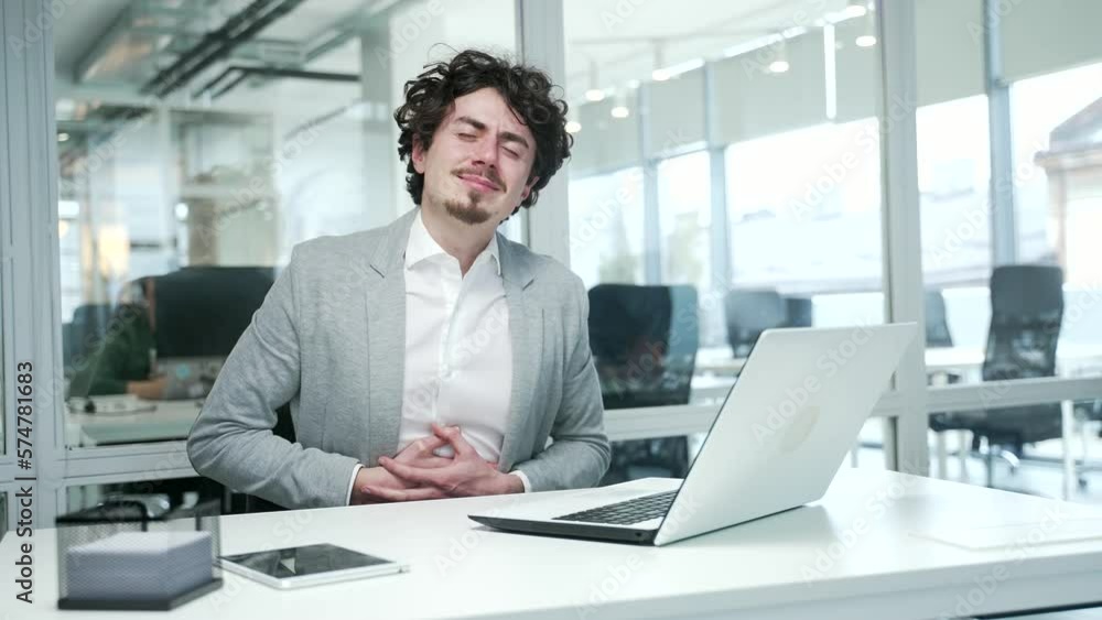 Sick business man suffering from stomach gastritis ache feeling bad while typing on laptop at modern workplace Unhealthy bearded creative freelancer holding belly with indigestion or poisoning at desk Sick business man suffering from stomach gastritis ache feeling bad while typing on laptop at modern workplace Unhealthy bearded creative freelancer holding belly with indigestion or poisoning at desk