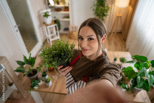 One woman young caucasian female stand at home hold flower plants pot