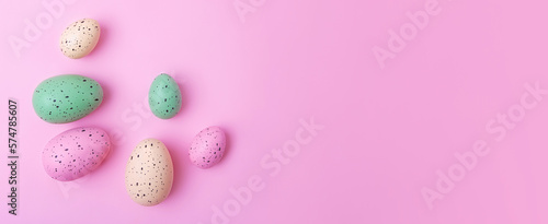 Frame from multicolored eggs on pink background,Easter concept.Large banner with negative space.