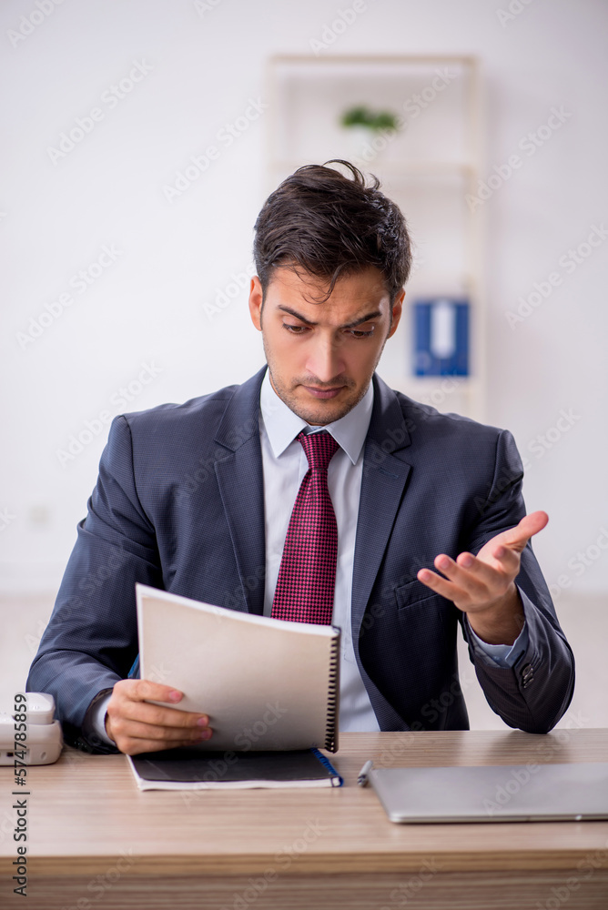 Young male employee working in the office Young male employee working in the office