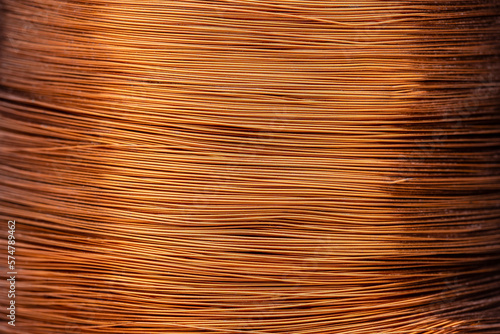 Metal texture of a coil of copper wire, closeup. Coil of thin copper wire on background