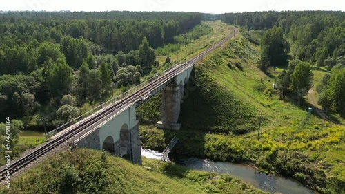 Aerial view of a train track bridge, railway bridge over the River Rauna, Latvia. Highest railway structure in Baltic countries. Endless railway without train. Empty straight single-way track.