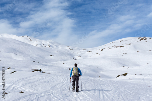 Man is snowshoe hiking in alpine winter mountains. Berlingerskoepfle, Haehlekopf, Vorarlberg, Austria.