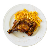 Tasty baked rabbit dish on a plate along with french fries. Isolated over white background