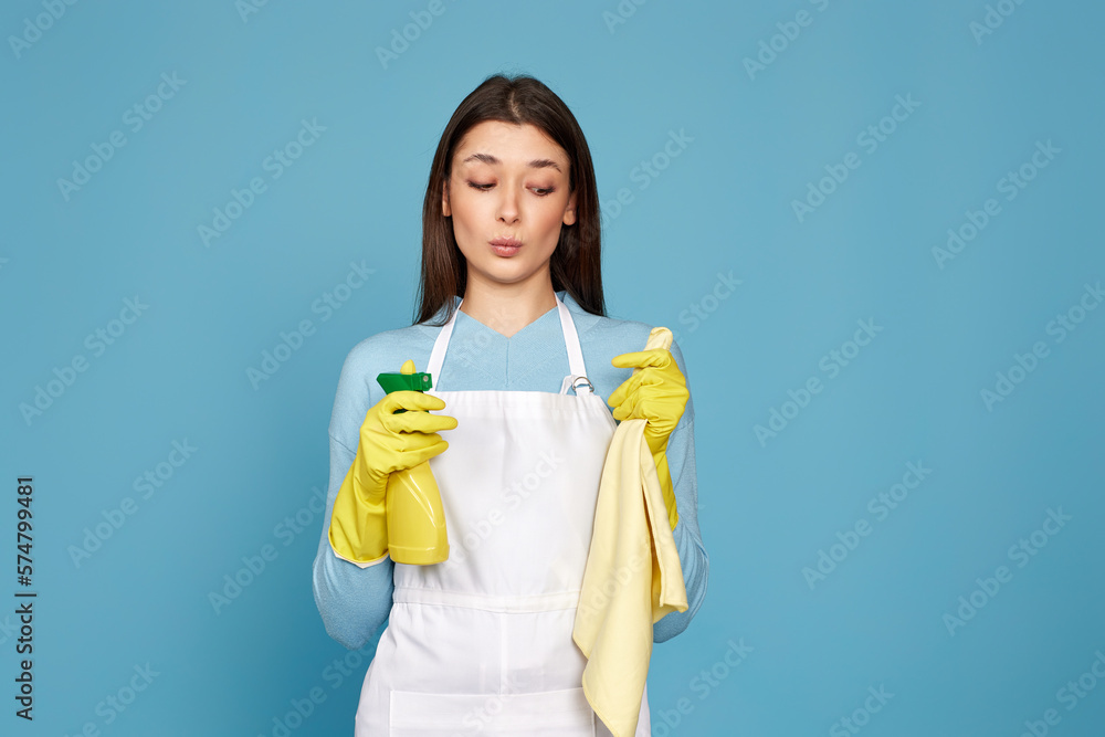 woman in cleaner apron with cleaning rag and detergent sprayer woman in cleaner apron with cleaning rag and detergent sprayer