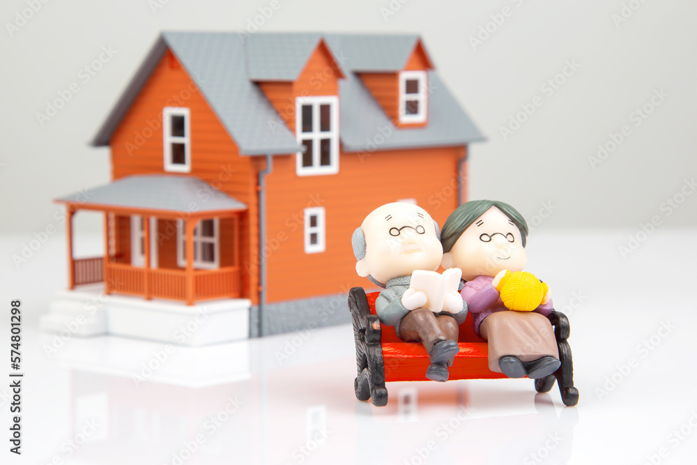 miniature people. a couple of retired people near the house model on a white background. financial security and pension for the elderly. concept of financial independence miniature people. a couple of retired people near the house model on a white background. financial security and pension for the elderly. concept of financial independence