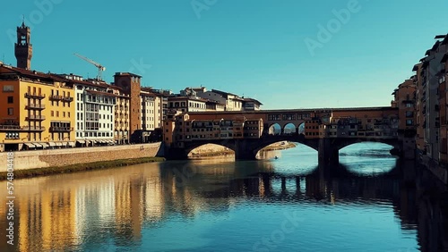 Arno River in Florence, Italy. Beautiful sunset over the river of the famous Italian city. River flows under the bridge on a sunny day. Ponte Vecchio and Ponte alla Carraia. Seagulls and clear skies. photo