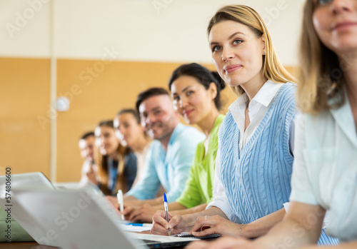 Small group of students attentively listening to lecture in university classroom
