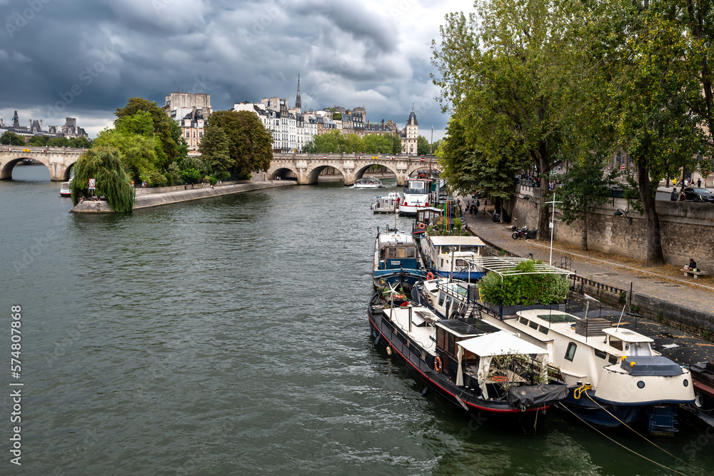 River Seine With Tourist Boat and Bridge Pont Neuf In Front Of Cathedral Notre Dame On Ile De La Cite In Paris, France