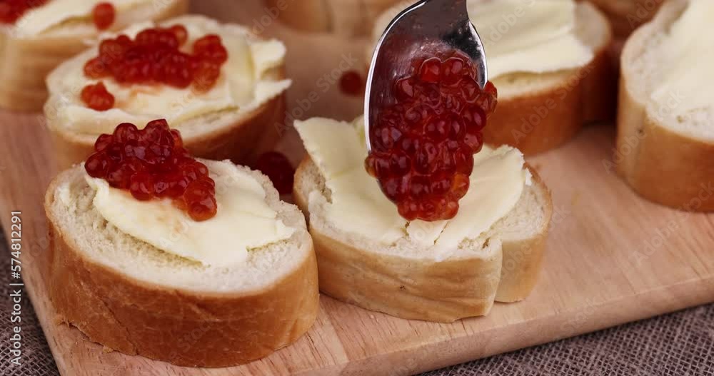 Thinly sliced baguette with salmon caviar and butter, delicious sandwich with bread, butter and natural red caviar Thinly sliced baguette with salmon caviar and butter, delicious sandwich with bread, butter and natural red caviar