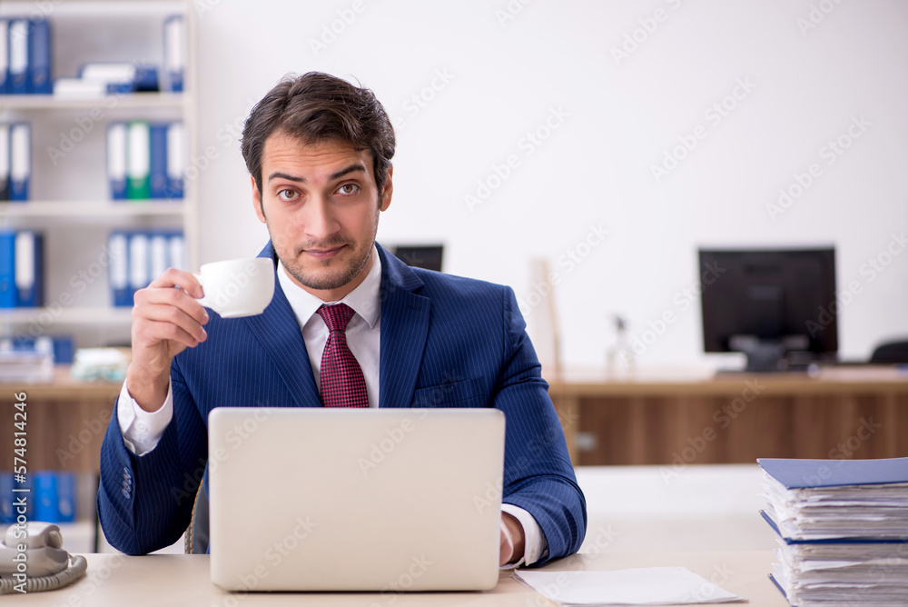 Young male employee drinking coffee during break Young male employee drinking coffee during break