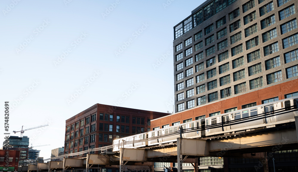 Chicago, Illinois, USA, February 19, 2023: A landscape view of the light rail passing through the Fulton Market District in Chicago, Illinois at dusk