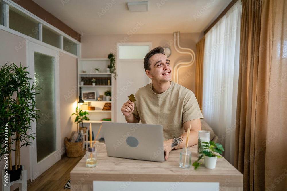 Fototapeta premium happy man online shopping use credit card laptop computer at home