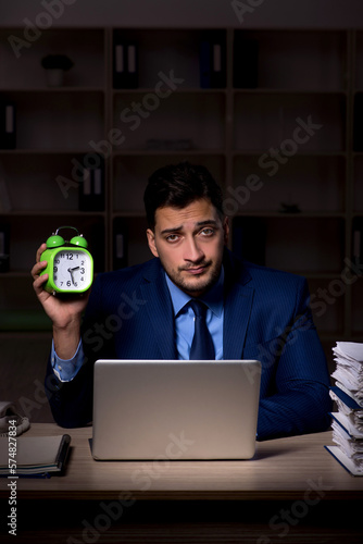 Young male employee working late in the office