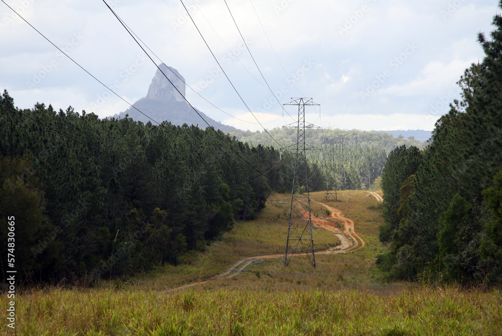 Dirt track with the high-voltage electricity lines with a mountain in the background