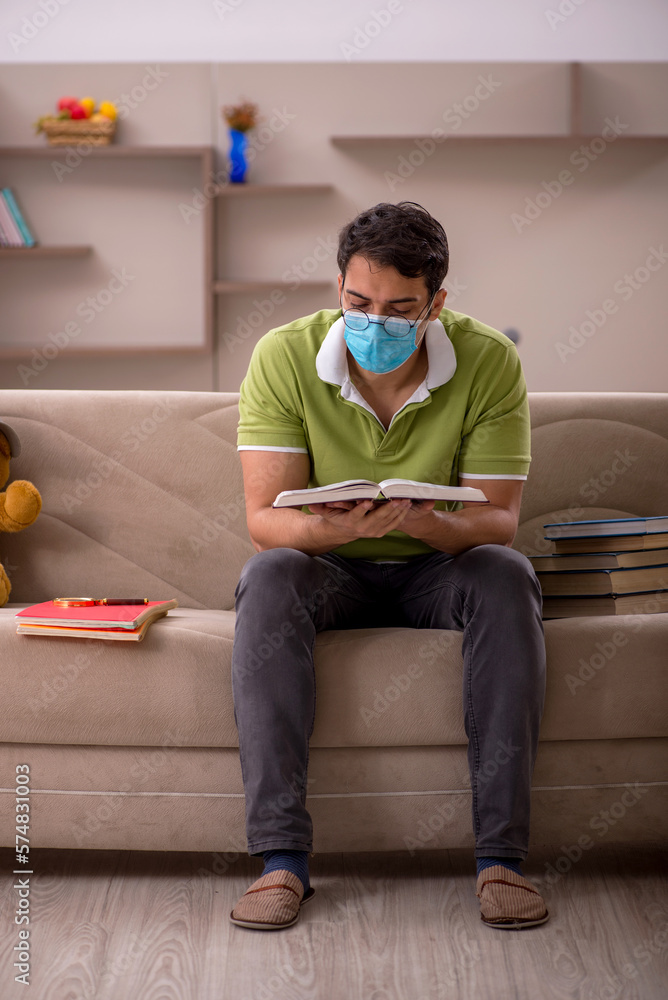 Young male student preparing for exams at home during pandemic
