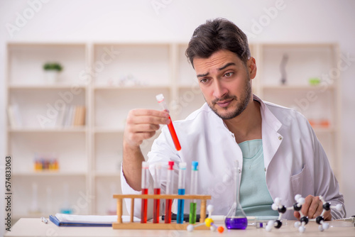 Young male chemist sitting at the lab