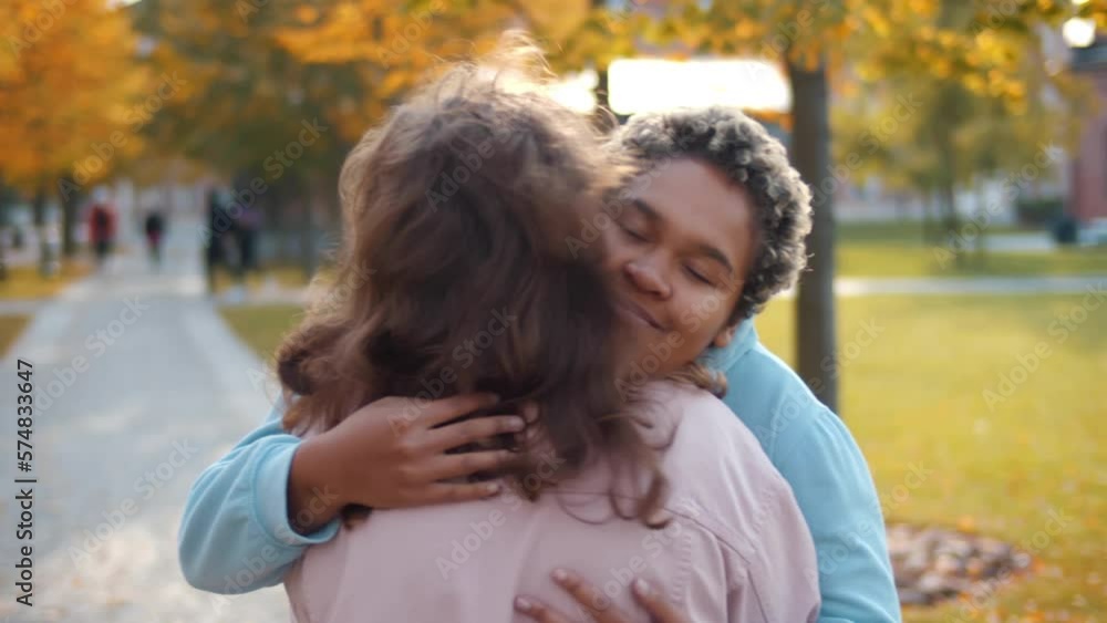 Diverse female friends greet each other meeting in park. Realtime Diverse female friends greet each other meeting in park. Realtime