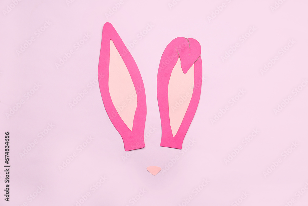 Paper bunny ears and nose on color background