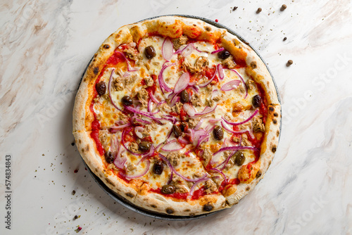 Pizza with tuna and red onion with olives and tomato sauce on marble table top view