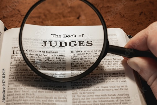 title page book of Judges close up using magnifying glass in the bible or Torah for faith, christian, hebrew, israelite, history, religion, christianity, Old Testament photo