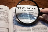 title page book of the Acts of the Apostles close up using magnifying glass in the bible for faith, christian, hebrew, israelite, history, religion, christianity, new testament