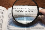 title page book of Romans close up using magnifying glass in the bible for faith, christian, hebrew, israelite, history, religion, christianity, new testament