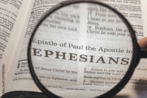 title page book of Ephesians close up using magnifying glass in the bible for faith, christian, hebrew, israelite, history, religion, christianity, new testament photo