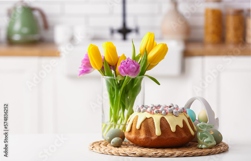 Photography Easter cake, painted eggs, tulip flowers and bunny on table in kitchen
