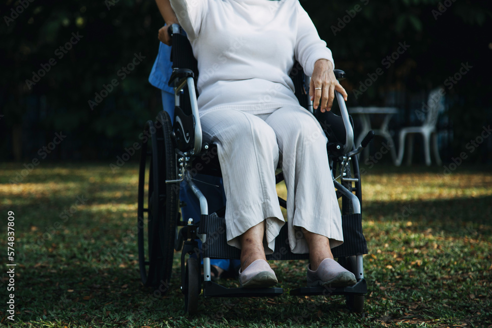 Obraz premium Asian young caregiver nurse support senior older male walking outdoors. Specialist girl doctor help and take care of elderly mature man patient doing physical therapy in public park at nursing home.