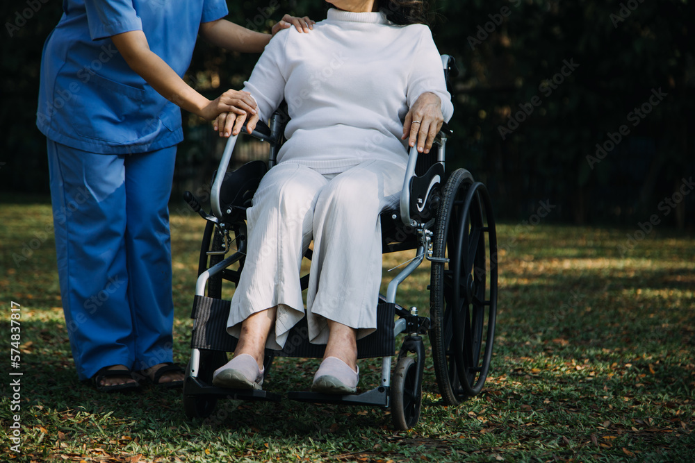 Obraz premium Asian young caregiver nurse support senior older male walking outdoors. Specialist girl doctor help and take care of elderly mature man patient doing physical therapy in public park at nursing home.