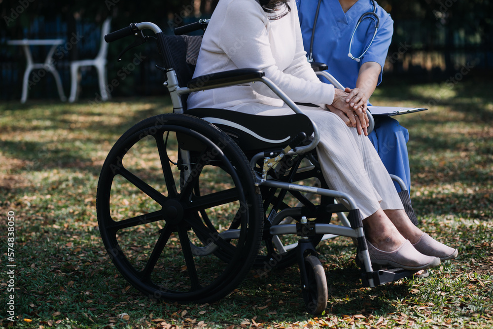 Obraz premium Asian young caregiver nurse support senior older male walking outdoors. Specialist girl doctor help and take care of elderly mature man patient doing physical therapy in public park at nursing home.