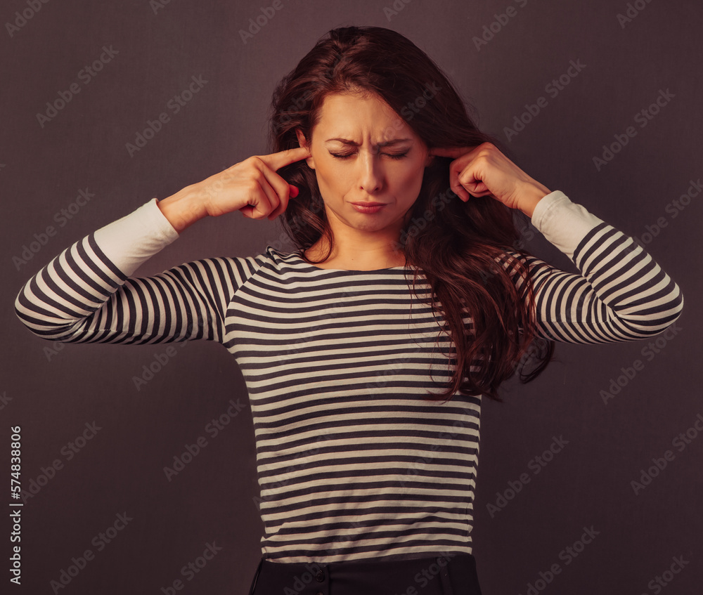 Portrait of beautiful business woman closed her ears the fingers with closed eyes. Toned closeup portrait Portrait of beautiful business woman closed her ears the fingers with closed eyes. Toned closeup portrait