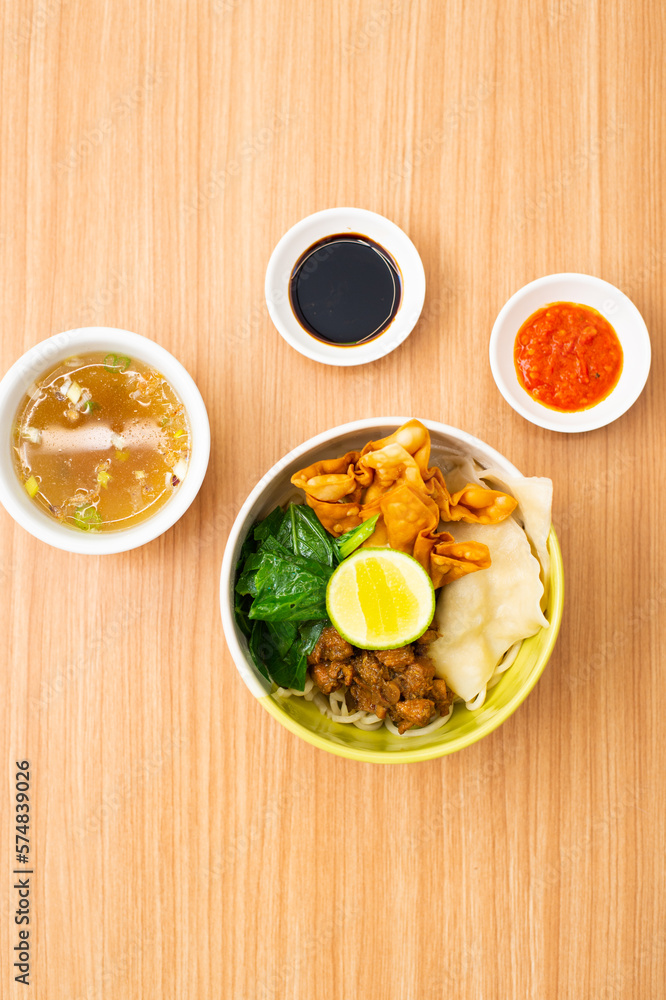 An bowl of chicken noodles served with potstickers An bowl of chicken noodles served with potstickers