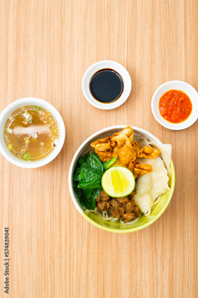 An bowl of chicken noodles served with potstickers An bowl of chicken noodles served with potstickers