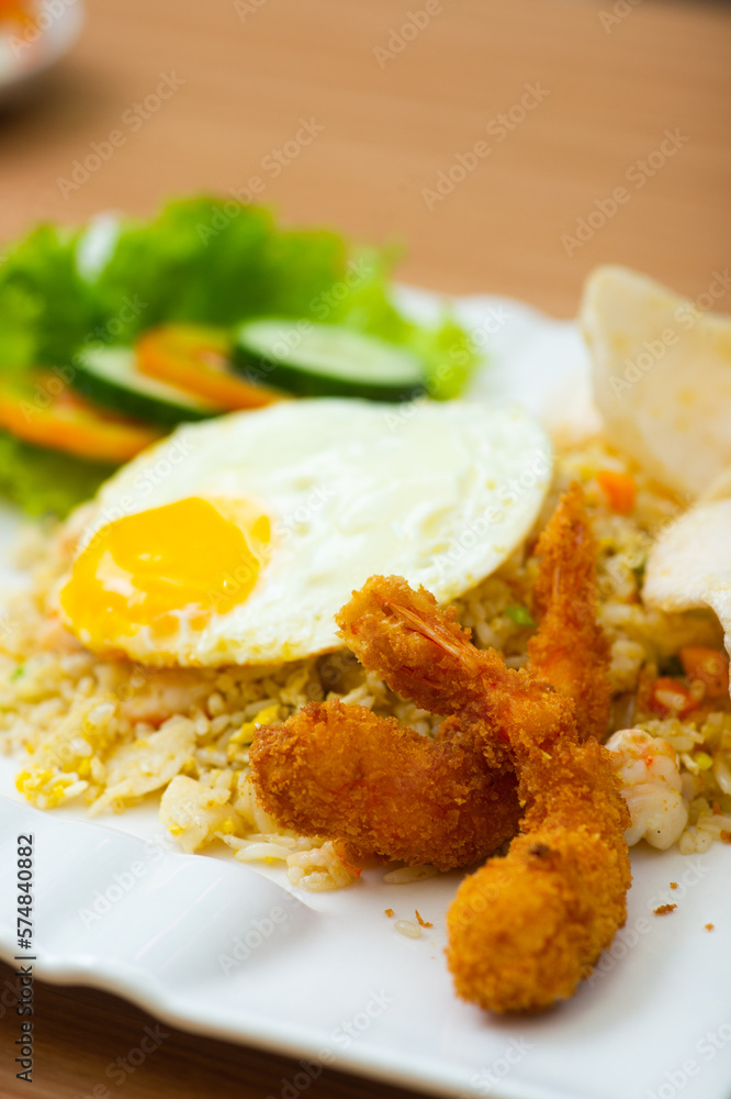 A Plate of seafood fried rice served with a side of shrimp fritters A Plate of seafood fried rice served with a side of shrimp fritters