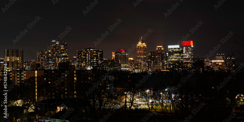 Fototapeta premium Atlanta City Skyline at Night with Skyscrapers and Buildings at Cloudy Twilight over the Trees in Georgia