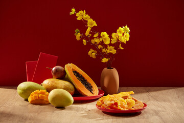 Apricot blossoms in a brown pot with various fruits and red envelopes. Chinese new year celebration. Front view. Decorative design elements.