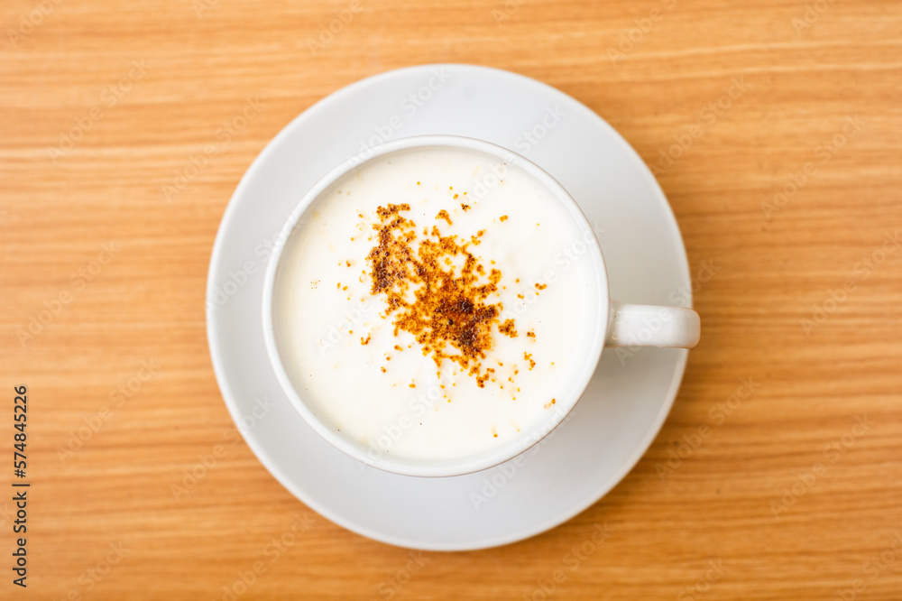 A Glass of cappucino coffee, sprinkled with coffee powder on top of the foam A Glass of cappucino coffee, sprinkled with coffee powder on top of the foam