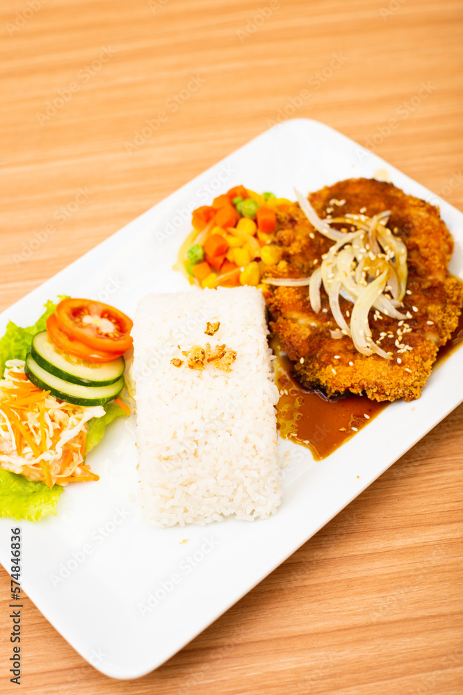 Chicken cutlet dish, served with rice and a side of salad topped with teriyaki sauce Chicken cutlet dish, served with rice and a side of salad topped with teriyaki sauce